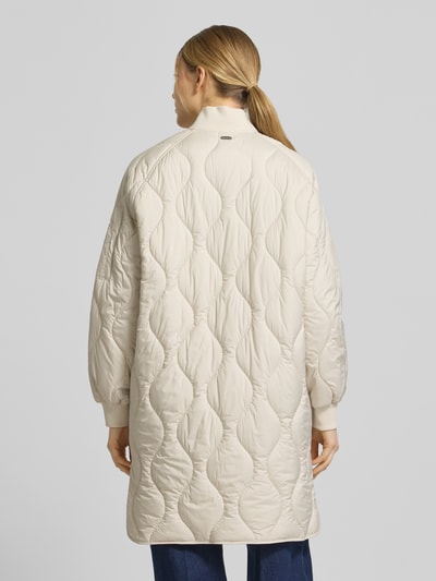 Frauenmodel trägt Steppmantel mit Ärmeltasche Modell 'AVON' von Beaumont Amsterdam in Beige, gesteppte Struktur, Gerade Passform, Ganzkörperansicht Rückansicht