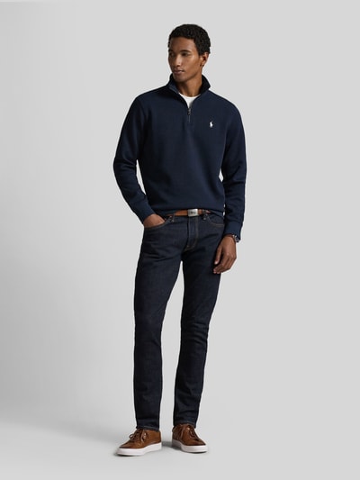 Männermodel trägt Relaxed Fit Troyer aus Baumwoll-Mix von Polo Ralph Lauren in Dunkelblau, kombiniert mit dunkler Jeans, Ganzkörperansicht von vorne.