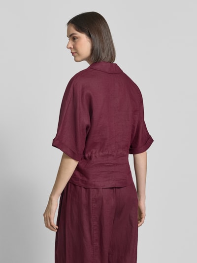 Frauenmodel trägt Relaxed Fit Leinenbluse mit Brusttaschen von Christian Berg Woman in Dunkelrot, reine Leinen, Rückenansicht Ganzkörperansicht.