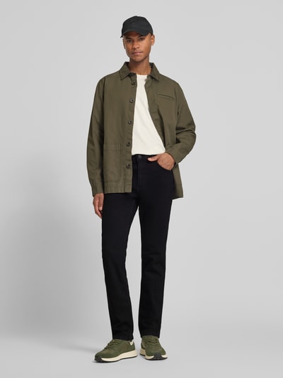 Männermodel trägt Straight Fit Jeans im 5-Pocket-Design Modell 'Greensboro' von Wrangler, Baumwoll-Mix mit Stretch-Anteil, Gerader-Schnitt, schwarze Farbe, Ganzkörperansicht von vorne.