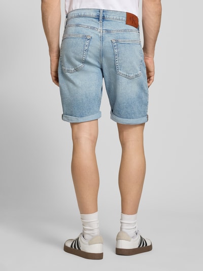 Männermodel trägt Slim Fit Jeansshorts aus Baumwoll-Mix Modell 'ABNER' von Calvin Klein Jeans in Denim-Optik, Label-Patch, 5-Pocket-Design, Ganzkörperansicht Rückansicht.