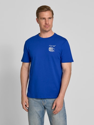 Männermodel trägt T-Shirt mit Motiv-Print Modell 'EGEBJERG' von Casual Friday in Blau, reine Baumwolle, Regular Fit, Ganzkörperansicht von vorne.