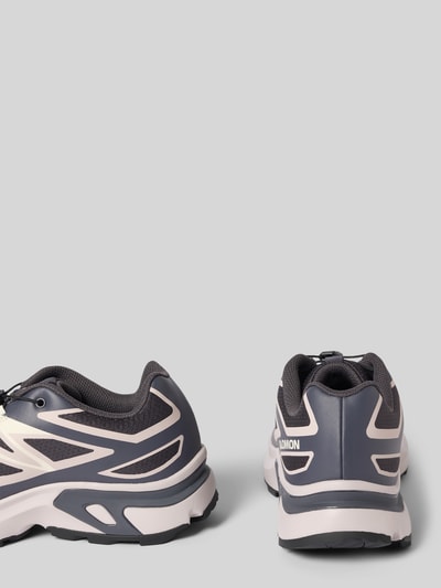Produktfoto, Sneaker mit profilierter Sohle Modell 'XT-EVR' von Salomon in Dunkelgrau mit weißen Akzenten, abgerundete Spitze, Schnürung, sichtbares Logo, strukturierte Textur, Absatzhöhe 3 cm, Schafthöhe 6 cm, Schaftweite 7 cm, Rückansicht.