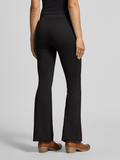 Frauenmodel trägt Slim Fit Schmale Hose mit elastischem Bund Modell 'FEVER' von ONLY, schwarze Farbe, Damen Schmale Hose, Ganzkörperansicht Rückansicht.