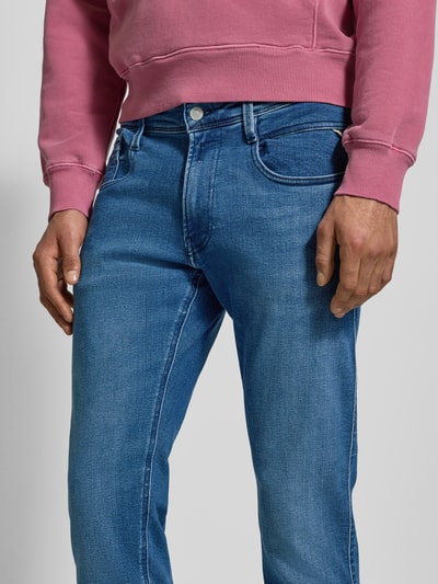 Männermodel trägt Slim Fit Jeans mit Eingrifftaschen Modell 'ANBASS' von Replay im Used-Look, Baumwoll-Mix mit Stretch-Anteil, Nahaufnahme Oberkörper.