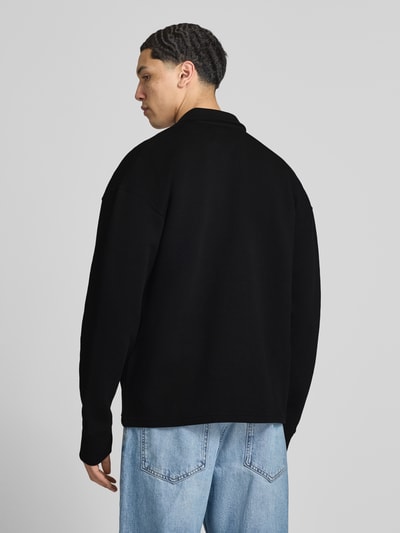 Männermodel trägt Oversized Sweatjacke mit Strukturmuster Modell 'Tate' von Pegador aus schwarzem Baumwoll-Mix mit Stretch-Anteil, Rückenlänge 69 cm, Ärmellänge 73 cm, Ganzkörperansicht Rückansicht.