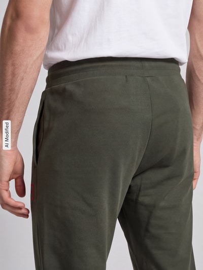 Mężczyznamodel nosi Regular Fit Sweathose aus Baumwoll-Mix model 'Laze Pants CW' von HUGO, zielony, gładka tekstura, Ganzkörperansicht Rückansicht, KI-modifiziertes Bild.