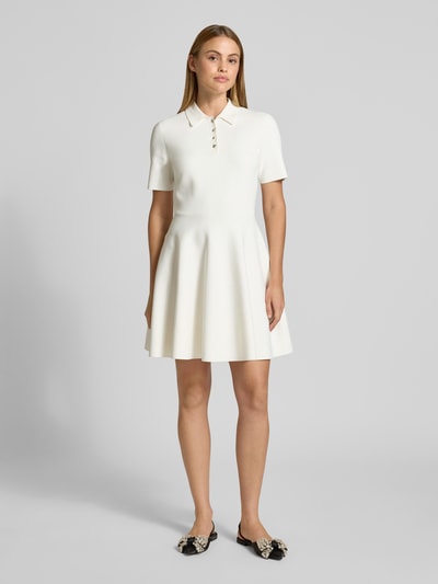 Frauenmodel trägt Polokleid mit kurzer Knopfleiste Modell 'RONDAA' von Ted Baker in cremeweiß, Viskose-Mix, taillierter Schnitt, Ganzkörperansicht von vorne.