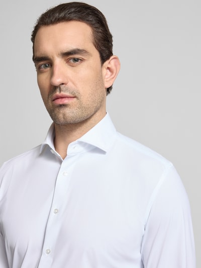 Männermodel trägt Slim Fit Business-Hemd mit Haifischkragen von Seidensticker aus Material-Mix mit Stretch-Anteil, Nahaufnahme Oberkörper.