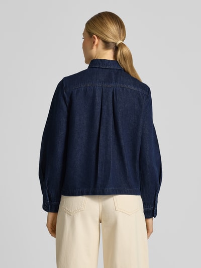 Männermodel trägt Jeansbluse mit Brusttaschen und Kentkragen von Stefanel, bawełniany miks, krój regular fit, sportowe mankiety, długość pleców w rozmiarze S: 58 cm, długość rękawa w rozmiarze S: 55 cm, widok całej sylwetki z tyłu.