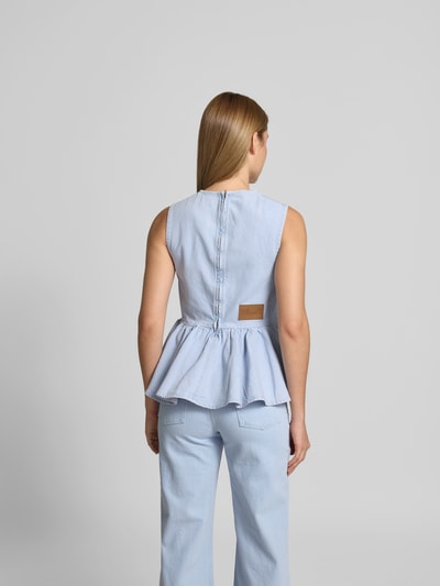 Frauenmodel trägt Slim Fit Top in Denim-Optik von BAUM & PFERDGARTEN aus elastischem Baumwoll-Mix mit Rüschen und Reißverschluss, Ganzkörperansicht Rückansicht.