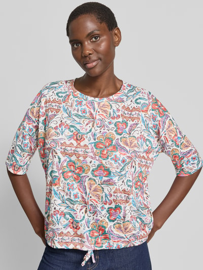Frauenmodel trägt T-Shirt im Allover-Look mit 3/4-Arm von Christian Berg Woman, Material-Mix mit Viskose-Mix, Rundhalsausschnitt, Regular-Fit, bunte Muster und strukturierte Oberfläche, Rückenlänge bei Größe S 52 cm, Ganzkörperansicht von vorne.