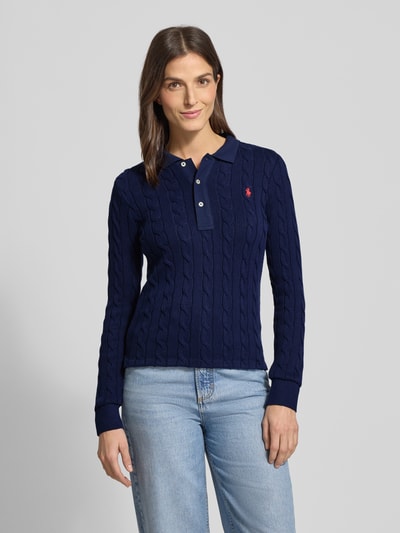 Vrouwenmodel draagt Gebreide pullover met kabelpatroon en polokraag van Polo Ralph Lauren, puur katoen, slim fit, labelstitching, knoopsluiting, ruglengte maat S 63 cm, mouwlengte maat S 66 cm, donkerblauw, structuur zichtbaar, nahaufnahme oberkörper.