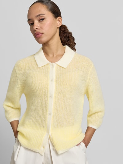 Frauenmodel trägt Cardigan mit Woll-Anteil und Polokragen von Fynch-Hatton, Material-Mix, Regular-Fit, Knopfleiste, 3/4-Arm, Rückenlänge 48 cm, Ärmellänge 39 cm, Pastellgelb mit feiner, leicht transparenter Textur, Nahaufnahme Oberkörper.
