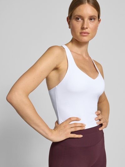 Frauenmodel trägt Slim Fit Top mit integriertem Bustier Modell 'Anywhere' von Fabletics in Weiß, elastischer Material-Mix, Nahaufnahme Oberkörper.
