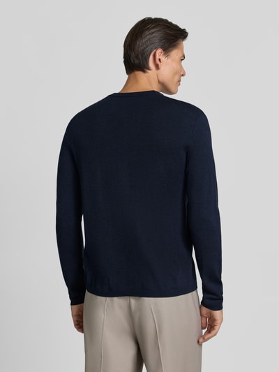 Männermodel trägt Strickpullover mit Henley-Kragen von DRYKORN, dunkelblau, reine Baumwolle, gerader Schnitt, Ganzkörperansicht Rückansicht.