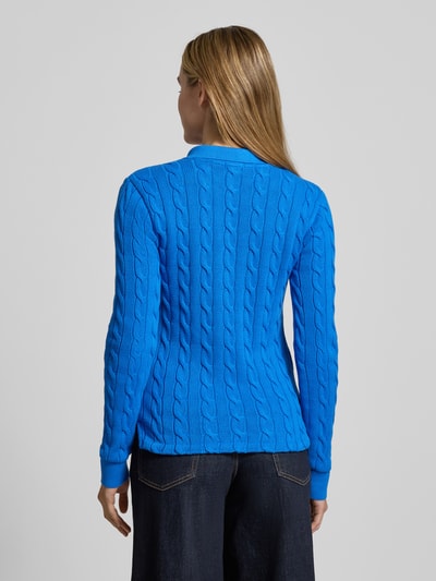 Frauenmodel trägt Strickpullover mit Zopfmuster und Polokragen von Polo Ralph Lauren in Blau, Slim Fit, Rückenansicht, reine Baumwolle.