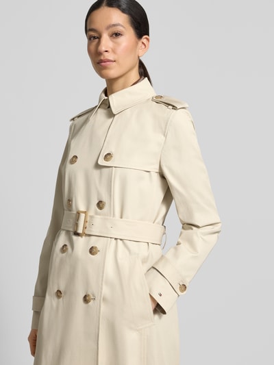 Vrouwenmodel draagt Slim Fit Trenchcoat aus reiner Baumwolle van Tommy Hilfiger in effen beige twill met dubbele knoopsluiting en riem, detailopname bovenlichaam