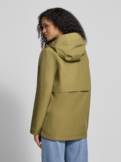 Frauenmodel trägt Regular Fit Funktionsjacke mit Kapuze Modell 'Elsa' von Didriksons in Olivgrün, glatte Textur, Rückenansicht, Ganzkörperansicht. Damenjacke mit Stehkragen und Eingrifftaschen, Rückenlänge 74 cm, Schulterbreite 42 cm, Brustweite 37 cm, Ärmellänge 63 cm.