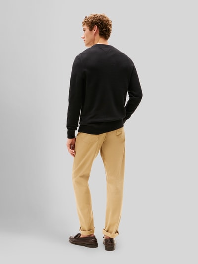 Männermodel trägt Regular Fit Strickpullover aus reiner Baumwolle von Tommy Hilfiger, unifarben schwarz, Rückenansicht Ganzkörperansicht.