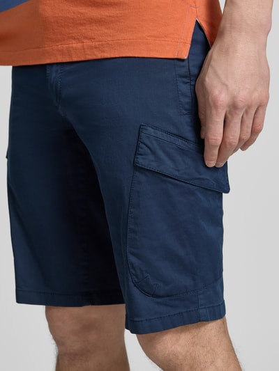 Männermodel trägt Regular Fit Cargoshorts aus Baumwoll-Mix von Brax, Optik: Unifarben, seitliche Eingrifftaschen, Nahaufnahme Oberschenkel.