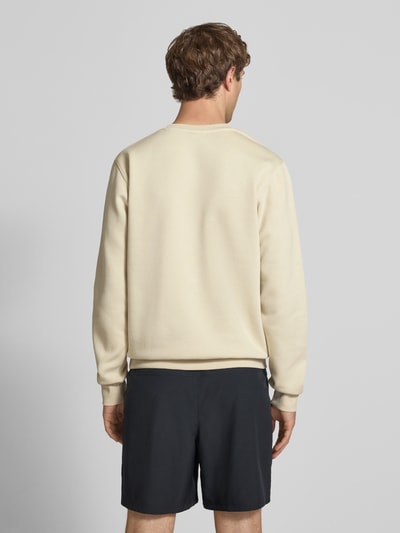 Männermodel trägt Sweatshirt mit Label-Stitching und Rundhalsausschnitt von Nike aus Baumwoll-Mix in Beige, Regular-Fit, Rückenlänge 69 cm, Ärmellänge 71 cm, Ganzkörperansicht Rückansicht.