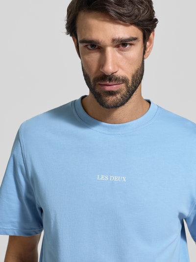 Männermodel trägt Herren T-Shirt mit Rundhalsausschnitt Modell 'Andrew' von Les Deux, Reine Baumwolle, Regular-Fit, Logo, Nahaufnahme Oberkörper.