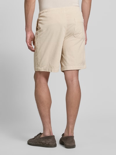 Męski model ma na sobie Regular Fit Sweatshorts aus Baumwoll-Mix von SELECTED HOMME, jasny beż, struktura sztruksu, tylna kieszeń, widok całego ciała z tyłu.