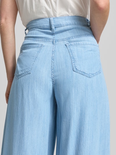 Frauenmodel trägt Wide Fit Jeans aus Lyocell-Mix Modell 'Eva' von Mango, hellblaue Farbe, Gesäßtaschen, Detailaufnahme Rückansicht. Damen Jeans, Eingriff- und Gesäßtaschen, Knopf- und Reißverschluss, Bundweite Größe 36: 40 cm, Innenbeinlänge Größe 36: 79 cm.