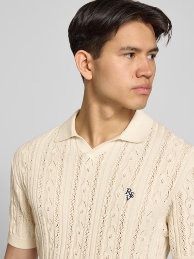 Männermodel trägt Slim Fit Strick-Poloshirt mit Label-Stitching von REVIEW, Reine Baumwolle, Zopfmuster, Nahaufnahme Oberkörper.