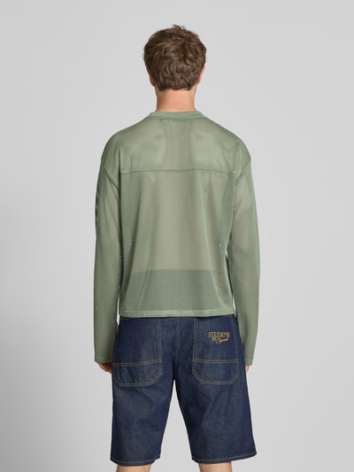 Männermodel trägt Longsleeve mit Label-Patch und Rundhalsausschnitt von KARL KANI, Boxy Fit, Rückenlänge 63 cm, Ganzkörperansicht Rückansicht.