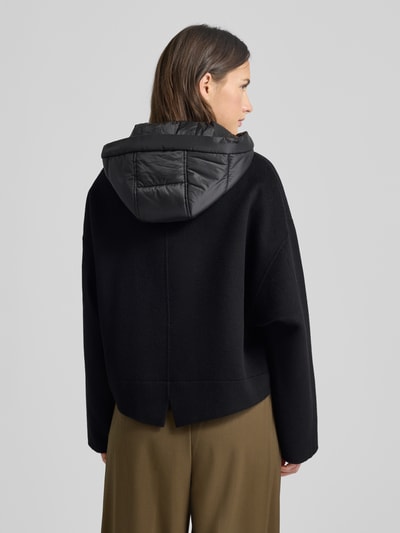 Vrouwenmodel draagt Jacke met Kapuze van Marc Cain in zwart, puur katoen, regular fit, steekzakken, ruglengte 57 cm, schouderbreedte 66 cm, borstwijdte 58 cm, mouwlengte 50 cm; geheel van achteren.