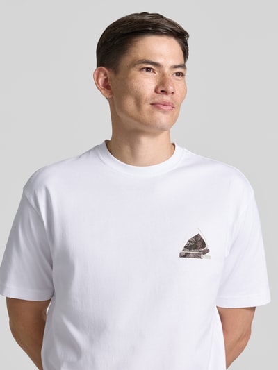 Męski model nosi Regular Fit T-Shirt aus reiner Baumwolle Modell 'TE_FRAME' von BOSS Orange, biała kolorystyka, gładka tekstura, nahaufnahme górnej części ciała.
