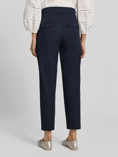 Frauenmodel trägt Regular Fit Hose aus Baumwoll-Mix Modell 'MARA S' von Brax in Dunkelblau mit Gürtelschlaufen und Gesäßtaschen, Ganzkörperansicht Rückansicht.
