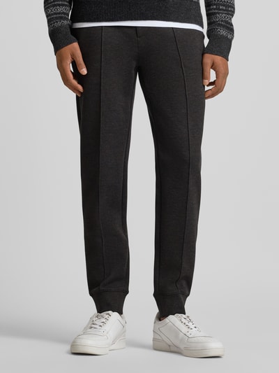 Męski model nosi Spodnie dresowe z elastycznym pasem od Polo Ralph Lauren, mieszanka bawełny, luźny krój, wpuszczane kieszenie, długość wewnętrzna 46 cm, kolor ciemnoszary, widok z przodu, zdjęcie całej sylwetki.