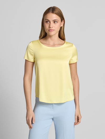 Frauenmodel trägt Blusenshirt mit Rundhalsausschnitt und abgerundetem Saum von Rinascimento in Gelb, Material-Mix mit Stretch, Loose Fit, Ganzkörperansicht von vorne.