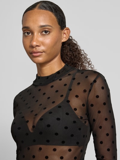 Vrouwenmodel draagt slim fit shirt met lange mouwen model 'JESHI' met zwart all-over motief van PIECES, dames, close-up bovenlichaam.