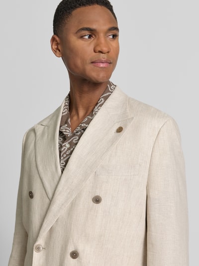 Männermodel trägt Regular Fit Sakko aus Leinen mit Pattentaschen von Christian Berg Men in Beige, Zweireiher, Nahaufnahme Oberkörper. Rückenlänge 74 cm, Schulterbreite 44 cm, Ärmellänge 65 cm, Reines Leinen, Reverskragen.