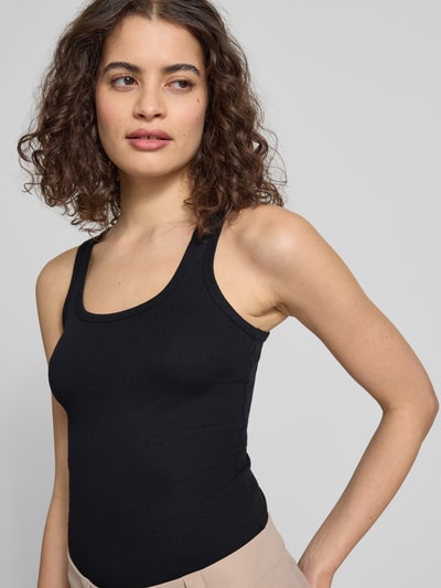 Frauenmodel trägt Tanktop mit Rundhalsausschnitt von Review aus Baumwoll-Mix mit Stretch-Anteil, Feinripp, Körpernaher-Schnitt, Nahaufnahme Oberkörper.
