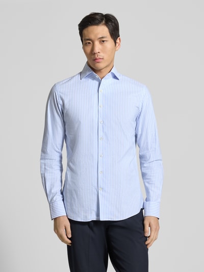 Męski model nosi Slim Fit Freizeithemd aus reiner Baumwolle Modell 'Oxford' von Profuomo, jasnoniebieskie paski, krój slim fit, koszula z kołnierzykiem kent, długim rękawem i zapięciem na guziki, długość tyłu w rozmiarze 40: 73 cm, szerokość ramion w rozmiarze 40: 46 cm, długość rękawa w rozmiarze 40: 66 cm, widok całej sylwetki z przodu.