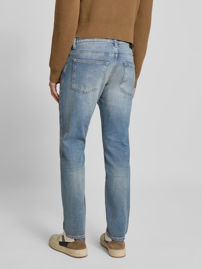 Männermodel trägt Slim Fit Jeans aus Baumwoll-Mix Modell 'DELAWARE BO' von BOSS Orange in Denim-Optik, 5-Pocket-Design, Label-Patch, Ganzkörperansicht Rückansicht.