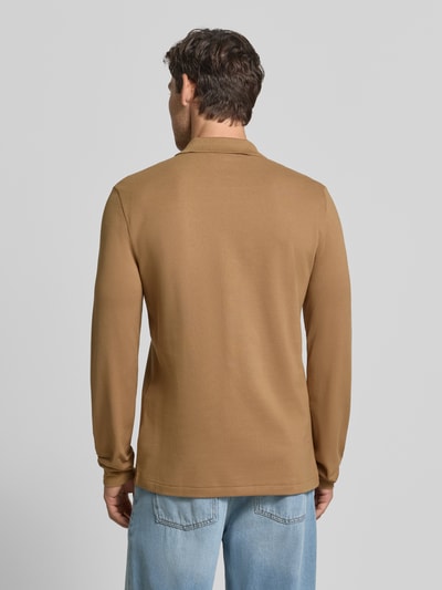 Männermodel trägt Regular Fit Poloshirt aus reiner Baumwolle von Lacoste in Braun, glatte Textur, Ganzkörperansicht Rückansicht.