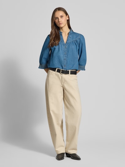 Vrouwenmodel draagt Regular Fit Jeansblouse uit puur katoen model 'RAYA' van Only, effen denim, rucheskraag, driekwart mouw, v-hals, elastische mouwzoom, afgeronde zoom, detail rugpas, voorkant volledig zichtbaar.