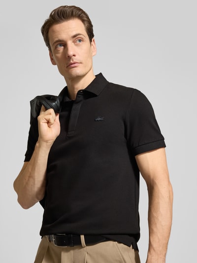 Męski model nosi Regular Fit Poloshirt aus Baumwoll-Mix von Lacoste, jednokolorowy, wyhaftowane logo, pika, mieszanka bawełny, nahaufnahme górnej części ciała.