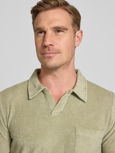 Männermodel trägt Relaxed Fit Poloshirt mit V-Ausschnitt von Lindbergh aus Baumwoll-Mix Frottee, Brusttasche, Nahaufnahme Oberkörper.