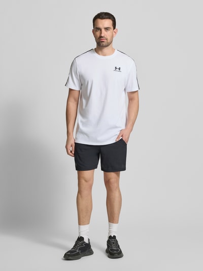 Męski model nosi Regular Fit T-Shirt mit Logo-Stitching Modell 'Icon' von Under Armour, biały bawełniany mix, krój regular fit, przód, zdjęcie całopostaciowe.