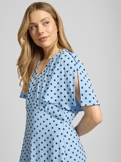 Kobiece modelka nosi sukienkę midi z dekoltem w serek model 'ZABBY' od ICHI, linia a, wzór na całej powierzchni, rękawy nietoperzowe, jasnoniebieski z czarnymi kropkami, szerokość w rozmiarze 36: 44 cm, długość tyłu w rozmiarze 36: 124 cm, długość rękawów w rozmiarze 36: 26 cm, zbliżenie górnej części ciała.