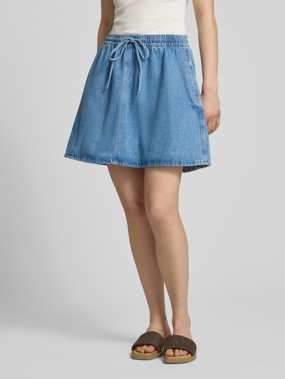 Frauenmodel trägt ausgestellten Jeansrock aus reiner Baumwolle von Marc O’Polo Denim in Hellblau mit elastischem Bund und Eingrifftaschen, Ganzkörperansicht von vorne.