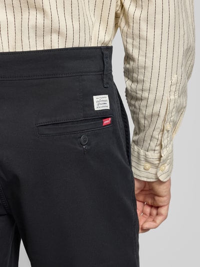 Männermodel trägt Regular Fit Chino Shorts aus Baumwoll-Mix von Levi's®, dunkler Stoff, Gesäßtasche mit Knopf, Detailaufnahme Rückansicht.