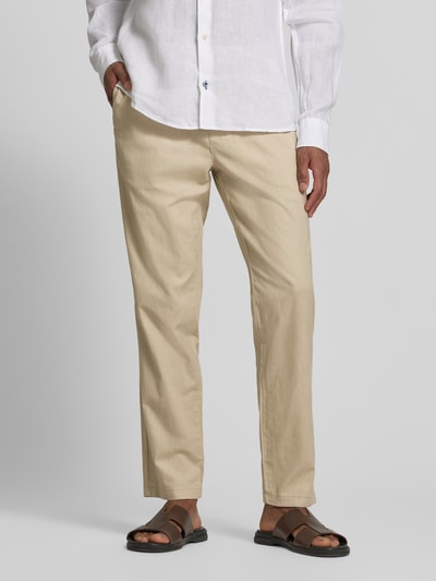 Męski model nosi Straight Fit Leinenhose mit elastischem Bund Modell 'Barton' von Matinique, mieszanka lnu i bawełny, spodnie z prostymi nogawkami, beżowy kolor, widok całej sylwetki z przodu, szerokość w rozmiarze M: 34 cm, długość wewnętrzna nogawki w rozmiarze M: 78 cm.